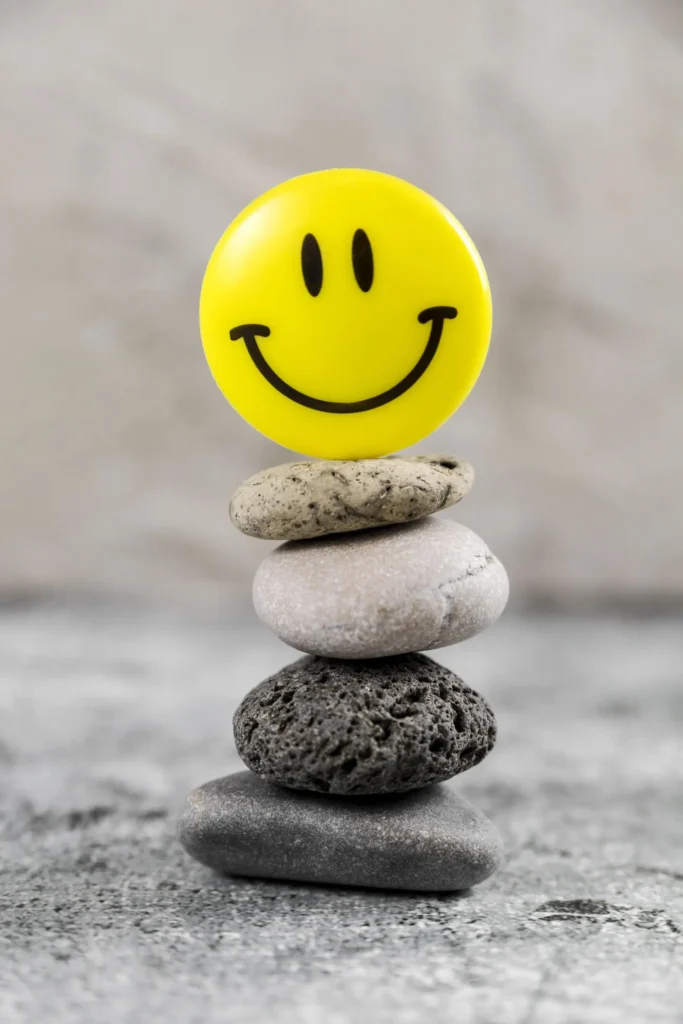 Smiley face on stacked stones symbolising happiness, balance and positive mental wellbeing