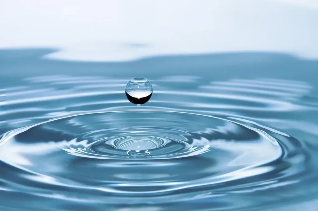 Water droplet creating ripple effect on surface, symbolising calm, balance and mindfulness